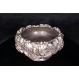 A Chinese silver circular bowl, the body embossed with iris, on a circular foot. Bowl has a white