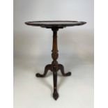 A Victorian tilt top table with pair crust edging on turned tripod base. Curved ball and claw