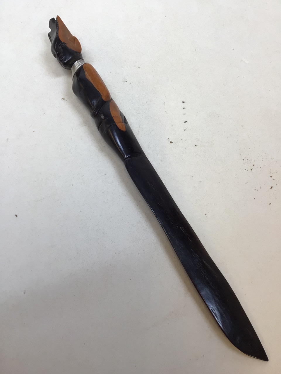 A carved figural ebony letter opener with metal collar Length 38cm