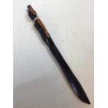 A carved figural ebony letter opener with metal collar Length 38cm
