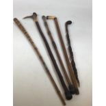 A collection of walking sticks to include a carved bamboo cane, a silver top and collar bone handled