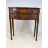 An early 20th century bow fronted console table with two drawers with brass handles on square