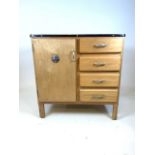 A kitchen cabinet by G Hollins and sons ltd with cupboard along side three drawers with metal top.