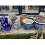 A blue glazed ceramic lion, two concrete pigs and a selection of pots.