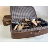 A large quantity of shoe stretchers and two suitcases.