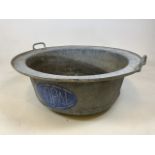 A large French vintage galvanised bowl., with blue and white painted logo to side . Perfect as a