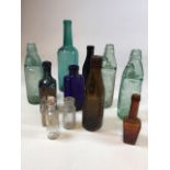 A collection of coloured glass bottles including Codds, blue glass, Starkey, Knight & Ford beer