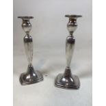 A pair of silver candlesticks, marked sterling 1450, engraving to base. Weighted bases. H:23cm