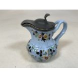 A nineteenth century hand painted ceramic jug with white metal lid. W:13cm x H:11cm