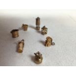 Seven 9ct gold charms. Weight approx 10gms. Includes a lamp, lantern, Toby jug, golf bag, bucket and