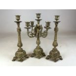 A brass four arm candelabra also with a pair of candlesticks. H:35cm