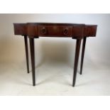 A small mahogany break front hall table with tapered legs, central bow fronted drawer with two brass