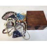 A quantity of costume jewellery in a wooden box.