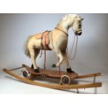 A mid - century rocking horse with leather saddle and harness. Horse can be detached from rockers