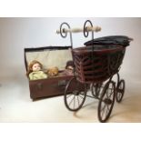 A vintage wicker and metal framed pram together with a suitcase with dolls and teddy bears. Doll