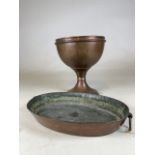 A large copper urn and a heavy copper oval pan with ring handles to side.