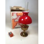 A vintage boxed Aladdin lamp with red shade and clear mantle. Marked Aladdin 23. 60cm height to