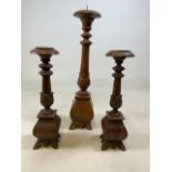 A pair of ecclesiastical style candlesticks and another.