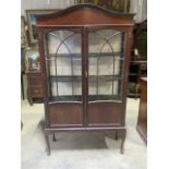 An early 20th century glazed display bookcase with curved top, three shelves glazed side panels.