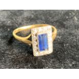 An Art Deco Ceylonese sapphire surrounded by diamonds. Size 8 or q. Plantinum with 18ct gold band.