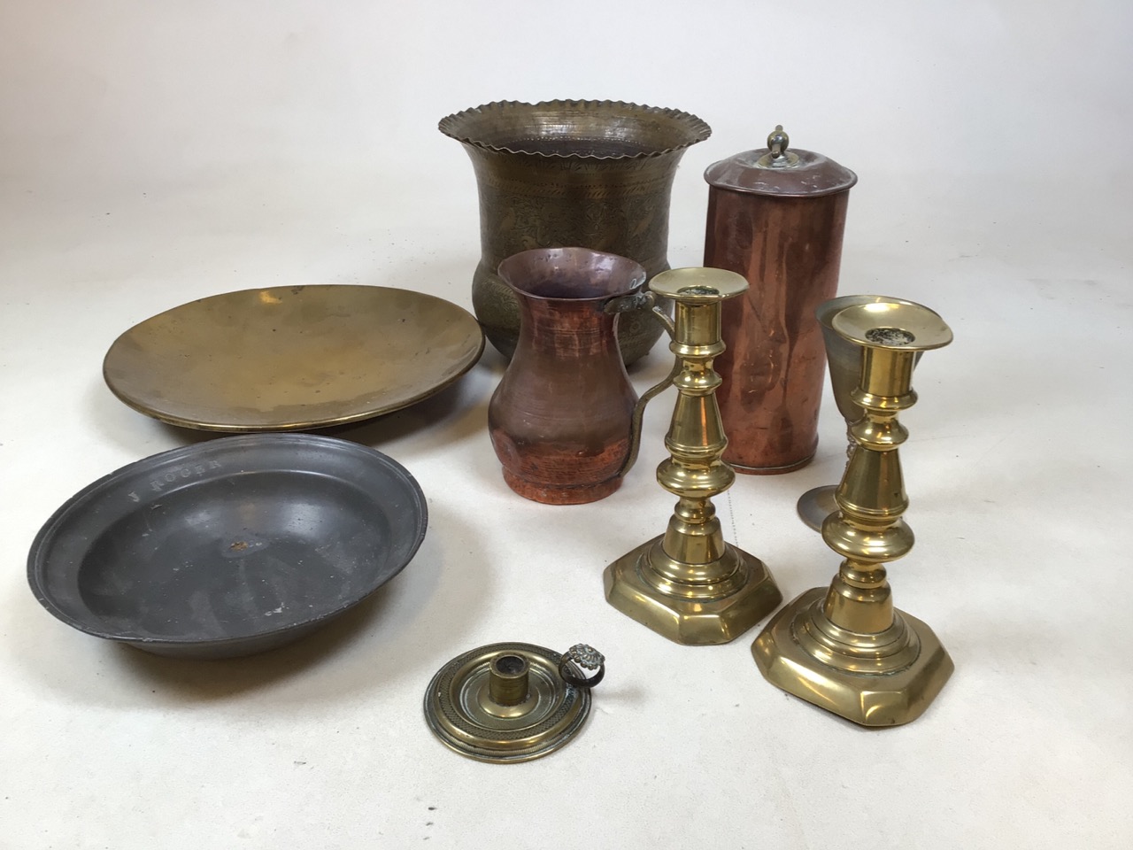 A quantity of brass and copper items including a pewter bowl marked J Roger