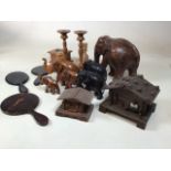 A collection of wooden elephants together with together with turned candle sticks, two chalet