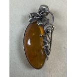 A Large amber and silver brooch.