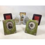 A collection of vintage photo frames. Including embossed leather, fabric with silver colour metal