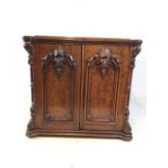 An late 19th early 20th century sewing cupboard walnut veneered with oak top. Carved detail