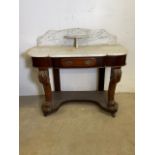 An early 20th century marble topped wash stand with central drawer, carved supports to base with