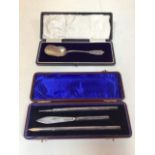 A boxed silver spoon with monogrammed handle together with a boxed silver pen, pencil and knife.