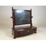 A nineteenth century bow fronted mahogany dressing table swing mirror with three drawers below (