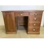 A solid pitch pine pedestal desk with central drawer, four pedestal drawers one side and large