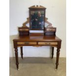 An early 20th century mahogany dressing table with large ceramic and brass castors, two large desk