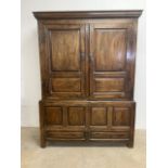 A large 18th century oak cupboard on coffer base with two interior shelves and storage. Signs of