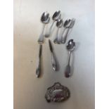 A collection of silver items including cutlery and a wine label. Total weight 198gm