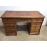 A 1920s pitch pine kneehole desk with nine drawers. W:123cm x D:58cm x H:73cm