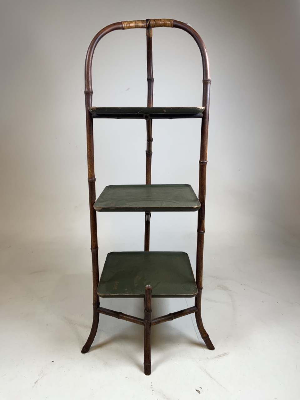 An oriental bentwood bamboo three tier stand, with green lacquer shelves with Oriental characters