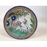 A decorative earthenware charger featuring wolves and a bird W:32cm