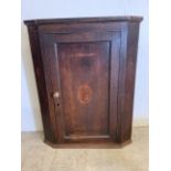 A narrow inlaid oak corner cupboard, interior with three shaped shelves. W:78cm x D:26cm x H: