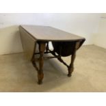 An oak gate leg table with pull out leg supports.W:139cm x D:184cm x H:75cm