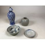 An oriental bowl with green celadon outer glaze and hand painted blue and white fish design to