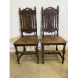 A Pair of oak hall chairs with carved backs and engraved seats. Seat height H:45cm