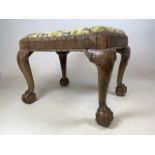 A carved piano stool on large ball and claw feet with drop in seat. W:64cm x D:50cm x H:50cm