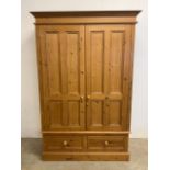 A modern pine double wardrobe with two drawers to base. W:125cm x D:60cm x H:197cm