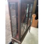 An early 20th century glazed bookcase with two interior shelves, glass side panels and fluted legs.