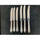 Three Sheffield silver handled table knives and three dessert knives.