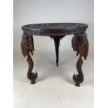 An early 20th century carved circular three legged elephant table with extensively carved top and