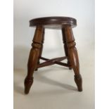A Round seated elm milking stool with x stretchers.