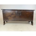 A 17th century oak coffer with adze caved panels, later top. W:89cm x D:32cm x H:45cm